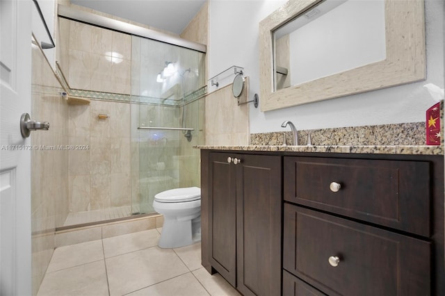 bathroom with toilet, vanity, tile patterned floors, and walk in shower