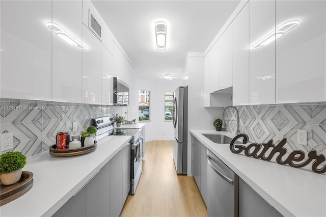 kitchen with backsplash, white cabinets, and stainless steel appliances