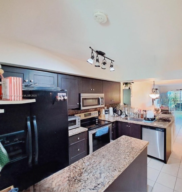 kitchen featuring light tile patterned flooring, appliances with stainless steel finishes, sink, hanging light fixtures, and dark brown cabinets