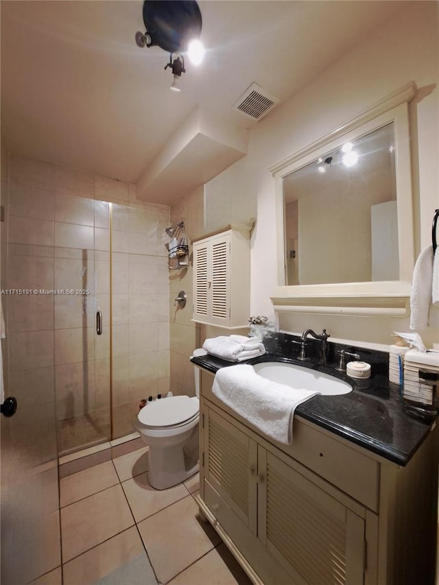 bathroom with vanity, toilet, tile patterned floors, and walk in shower