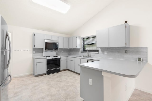 kitchen with kitchen peninsula, appliances with stainless steel finishes, tasteful backsplash, sink, and lofted ceiling