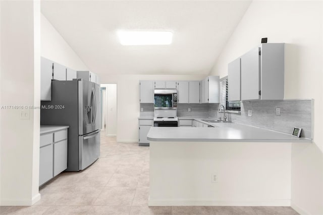 kitchen featuring kitchen peninsula, sink, stainless steel appliances, and vaulted ceiling