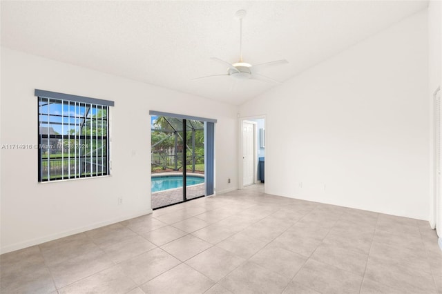 tiled spare room with vaulted ceiling and ceiling fan