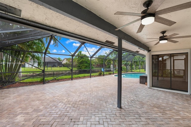 view of patio featuring ceiling fan and glass enclosure