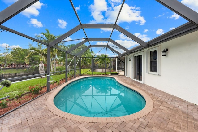 view of pool featuring a yard, a patio area, and a lanai