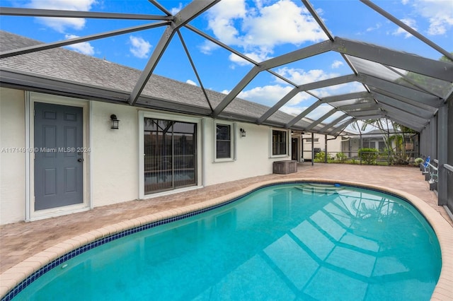 view of swimming pool featuring a lanai and a patio