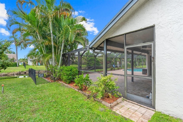 view of yard featuring glass enclosure and a fenced in pool