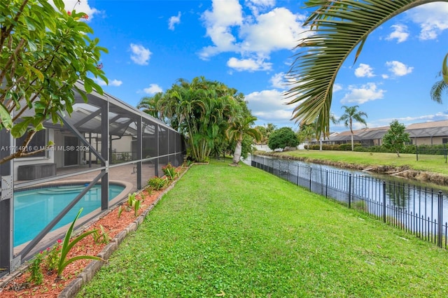 view of yard with a fenced in pool, glass enclosure, and a water view