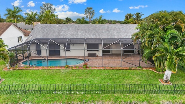 rear view of house featuring a patio area, a lanai, a yard, and a fenced in pool