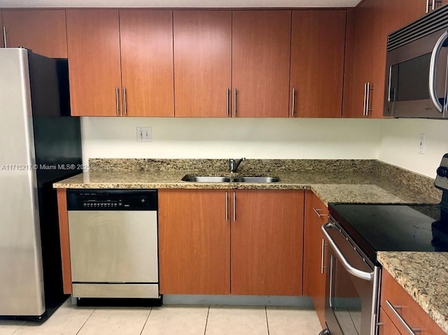 kitchen featuring light stone counters, sink, light tile patterned flooring, and appliances with stainless steel finishes