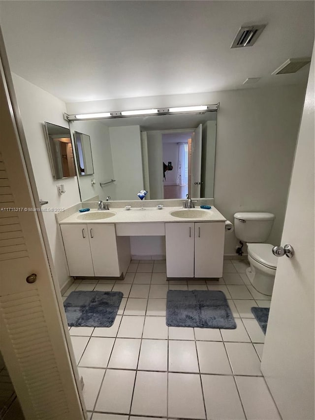 bathroom with tile patterned flooring, vanity, and toilet