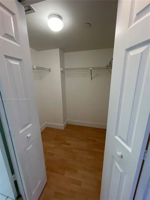 walk in closet with light wood-type flooring