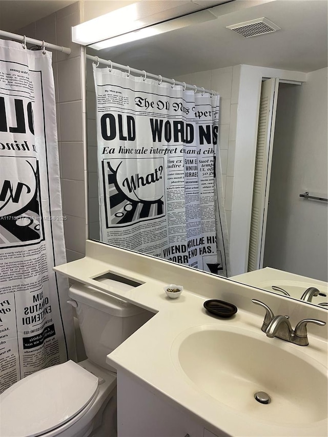 bathroom with curtained shower, vanity, and toilet