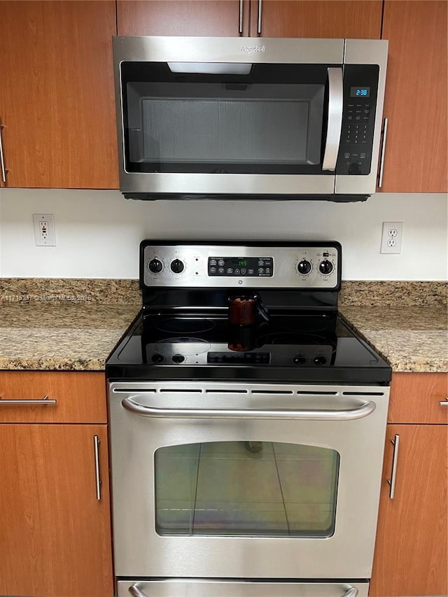 kitchen with light stone countertops and appliances with stainless steel finishes