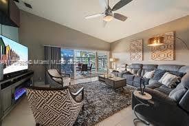 living room with ceiling fan and lofted ceiling