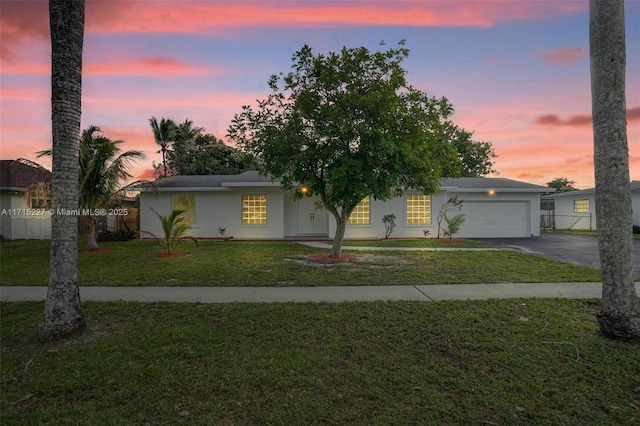 view of front facade with a yard and a garage