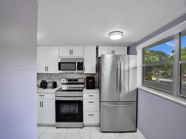 kitchen featuring decorative backsplash, white cabinetry, and stainless steel appliances