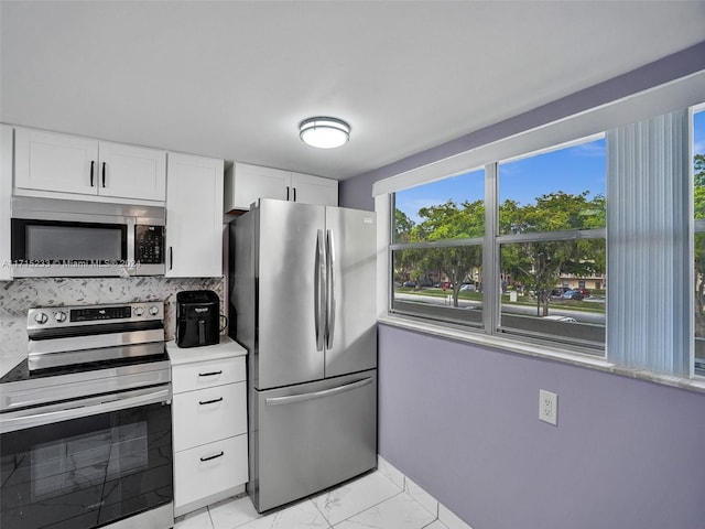 kitchen with decorative backsplash, white cabinetry, and stainless steel appliances