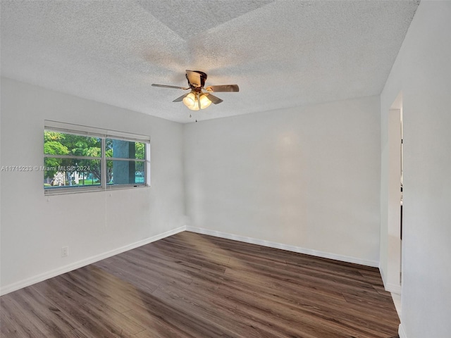 empty room featuring a textured ceiling, ceiling fan, and dark wood-type flooring