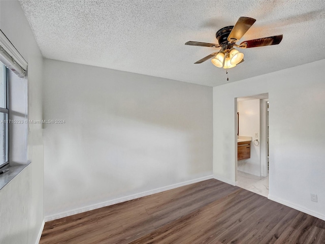 empty room featuring wood-type flooring, a textured ceiling, and ceiling fan