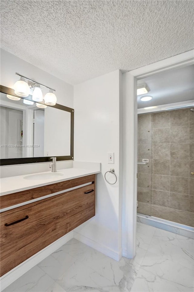 bathroom featuring vanity, a textured ceiling, and tiled shower