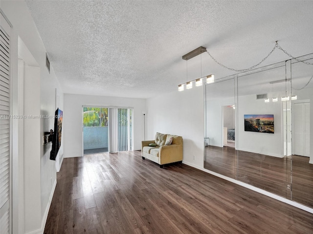 unfurnished room featuring a textured ceiling and dark hardwood / wood-style floors