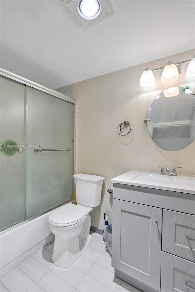 full bathroom with tile patterned floors, vanity, toilet, and enclosed tub / shower combo