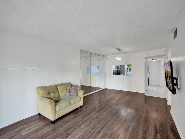 sitting room featuring a textured ceiling and dark wood-type flooring