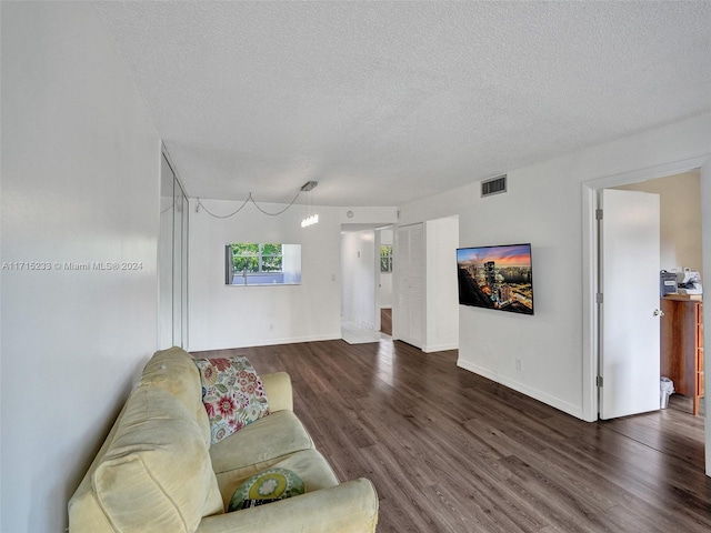 living room with dark hardwood / wood-style flooring and a textured ceiling