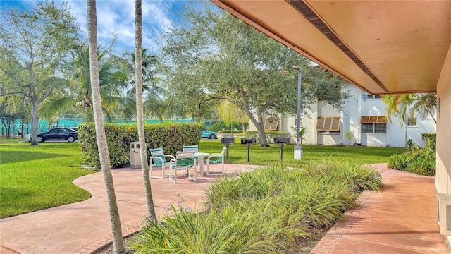 view of community with a yard and a patio area