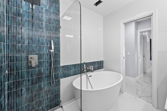 bathroom featuring a tub to relax in and tile walls