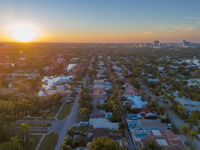 aerial view at dusk featuring a water view