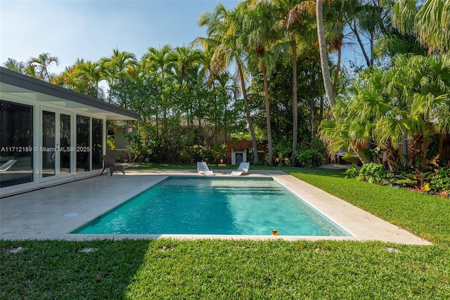 view of swimming pool featuring a yard and a patio