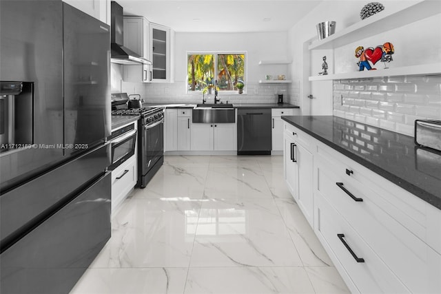 kitchen with sink, wall chimney exhaust hood, backsplash, white cabinets, and appliances with stainless steel finishes