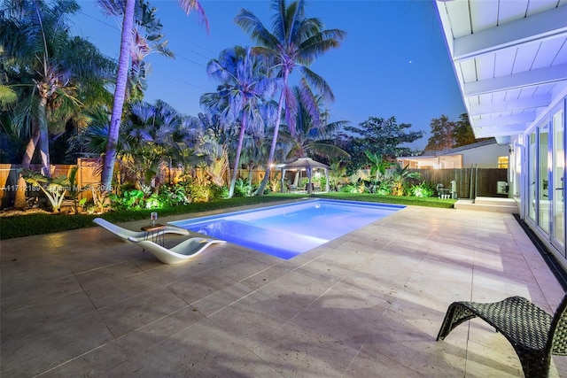 pool at dusk with a patio