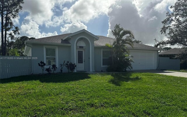 single story home featuring a garage and a front lawn