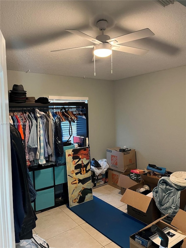 spacious closet with light tile patterned floors and ceiling fan