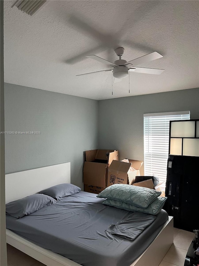 bedroom featuring ceiling fan and a textured ceiling