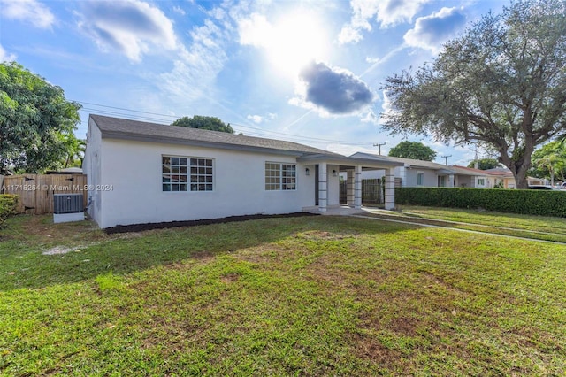 single story home featuring central AC unit and a front lawn