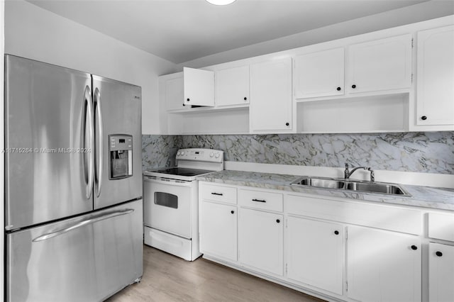 kitchen with electric stove, sink, stainless steel fridge with ice dispenser, decorative backsplash, and white cabinetry