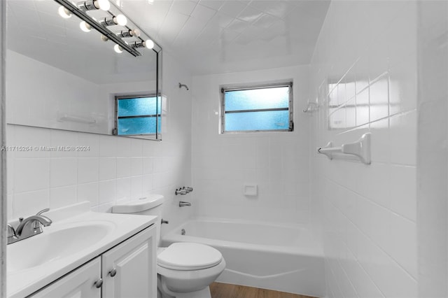 full bathroom with vanity, bathtub / shower combination, hardwood / wood-style flooring, toilet, and tile walls