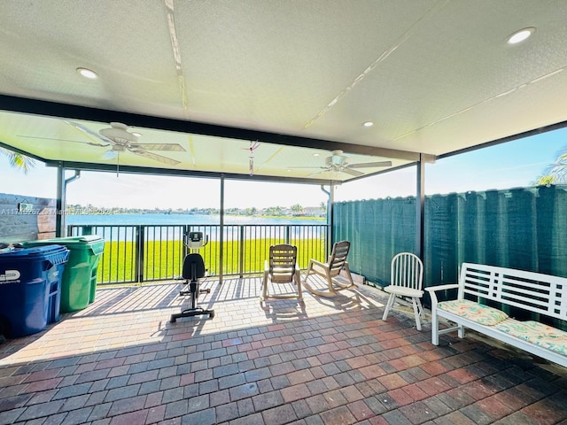 view of patio featuring ceiling fan and a water view