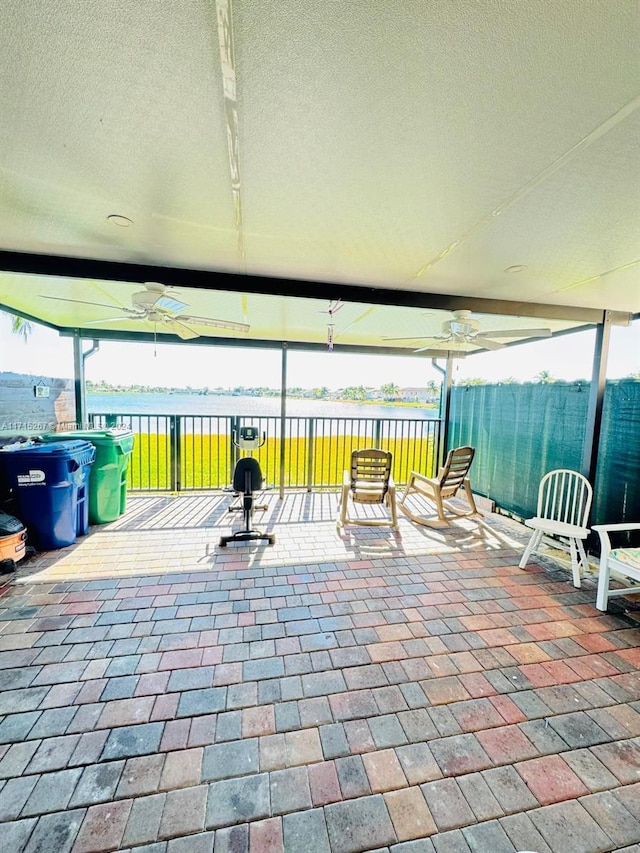 view of patio / terrace featuring ceiling fan and a water view