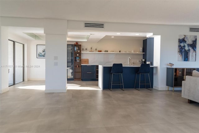 interior space with kitchen peninsula, a breakfast bar, and sink