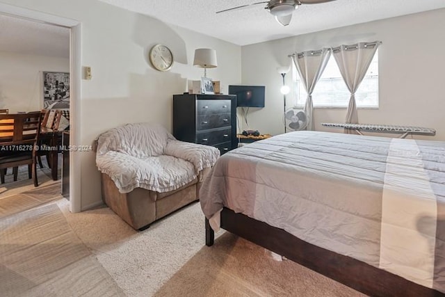 carpeted bedroom with a textured ceiling and ceiling fan