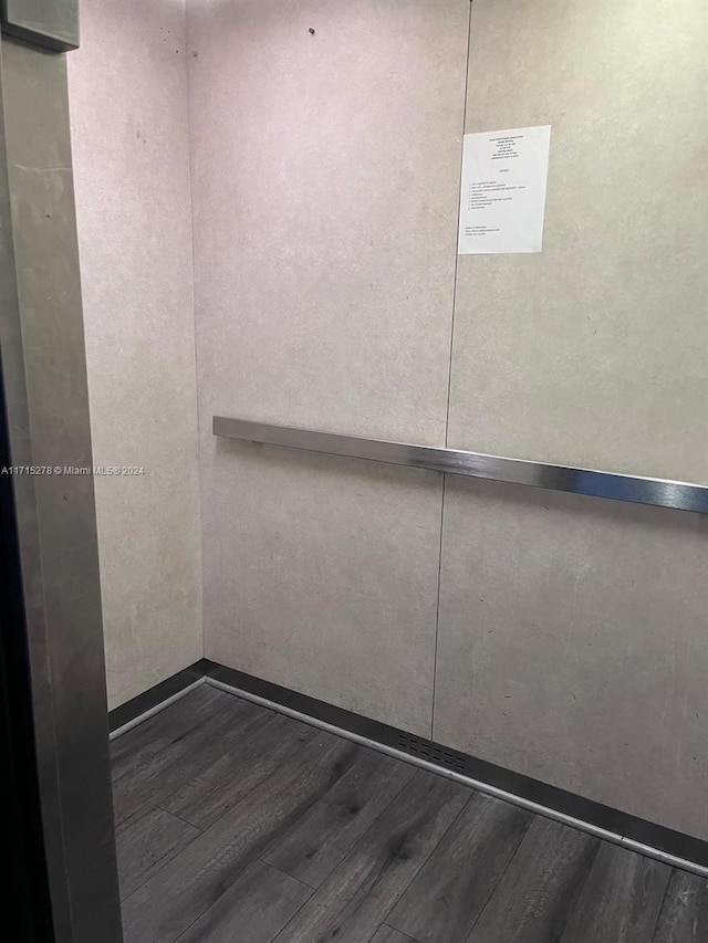 room details featuring elevator and wood-type flooring