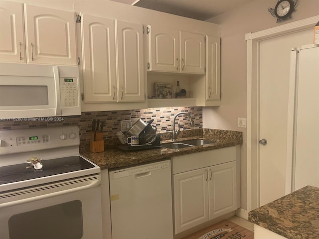 kitchen with white cabinets, backsplash, white appliances, and sink