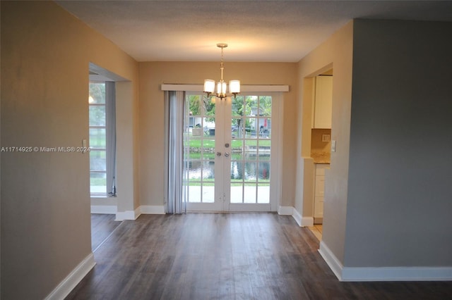 interior space featuring dark hardwood / wood-style floors, a notable chandelier, and french doors