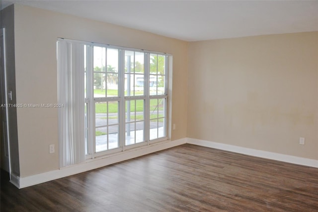 unfurnished room with dark wood-type flooring