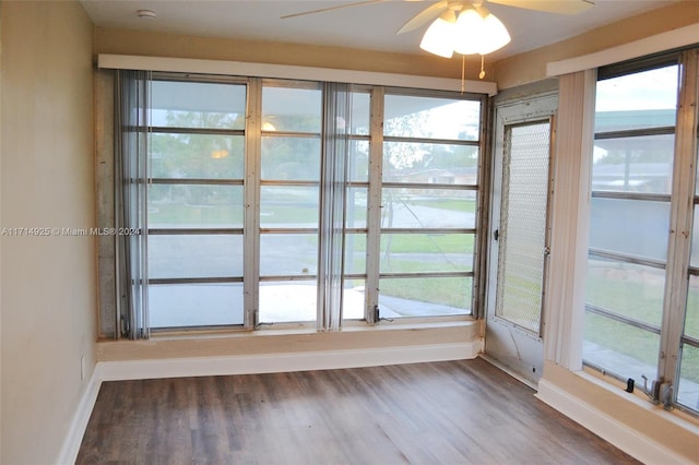 unfurnished sunroom featuring a water view and ceiling fan